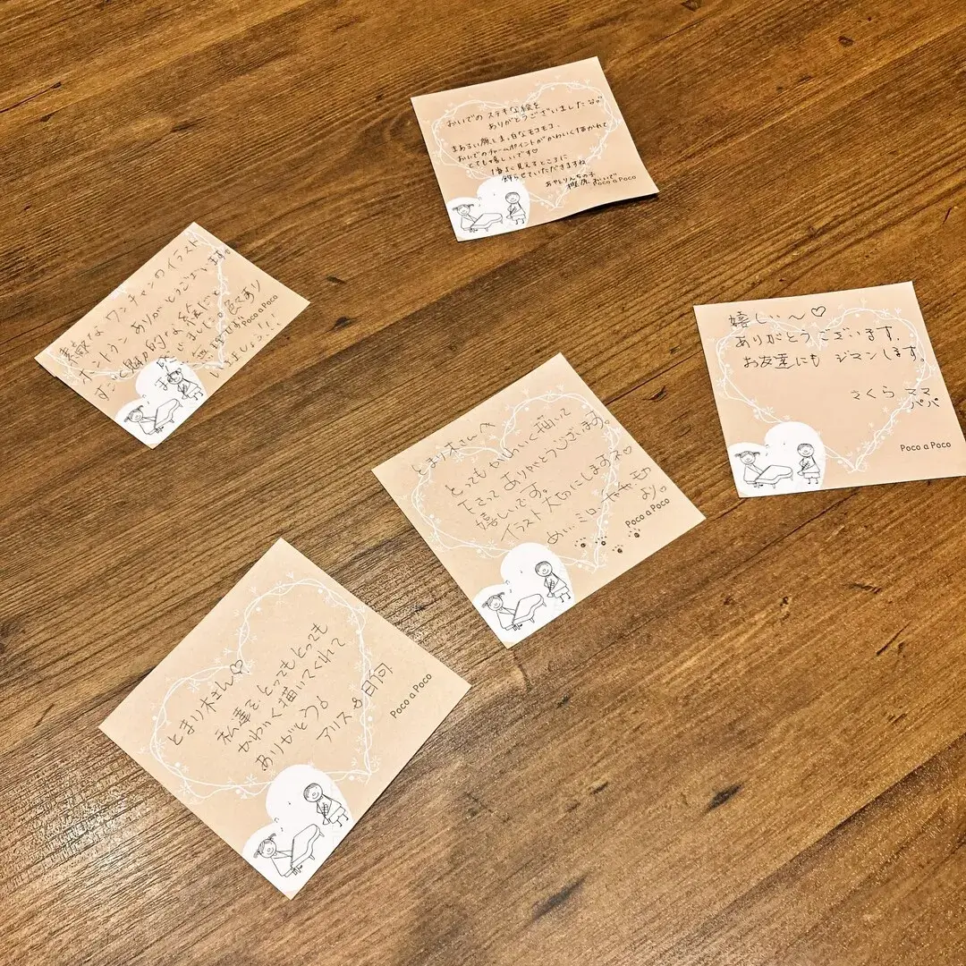 木目のテーブルの上に置かれた5枚の手書きメッセージカード