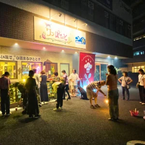 夜、お店の前で花火を楽しむ「ワンぽてぃと」の3周年記念パーティー参加者たち。