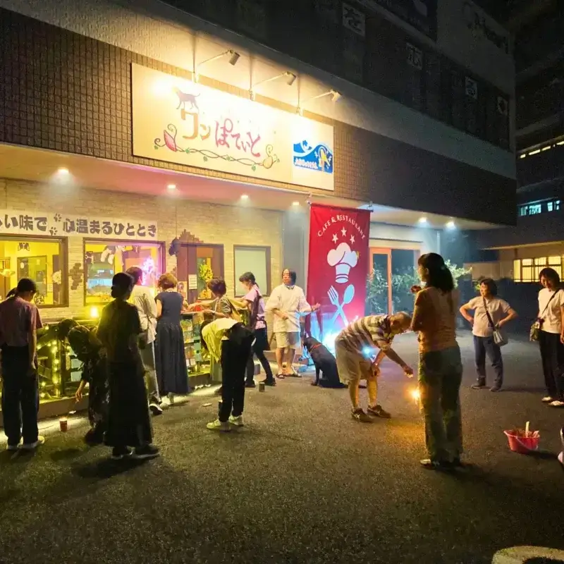 夜、お店の前で花火を楽しむ「ワンぽてぃと」の3周年記念パーティー参加者たち。