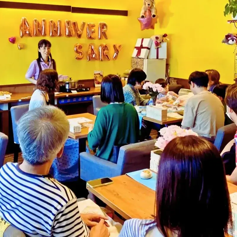 3周年記念パーティーで、マイクを持って参加者にご挨拶する「ワンぽてぃと」の女性オーナー。