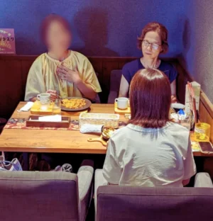 カフェレストランのテーブルで食事をしながら談笑する3人の女性。