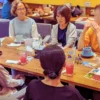 カフェレストランのテーブルで談笑する5人の男女。第4回ワン’s ペアレンツの和やかな交流の様子。
