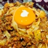 平打ちパスタのボロネーゼの中央に、満月に見立てた卵黄が乗っている「お月見ボロネーゼ」。卵黄の上には可愛らしいウサギの飾りが添えられている。