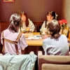 ワンぽてぃとで開催された第7回HANASOU-ZEの様子。テーブルを囲んだ4名の若い女性参加者が、飲み物を片手に笑顔で楽しそうに会話している。