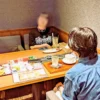 ワンぽてぃとの店内で、第9回HANASOU-ZEに参加した2名の若者がテーブルを挟んで向かい合い、真剣に、そして楽しそうに語り合っている様子。