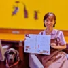 ワンぽてぃとオーナー小栗加奈と看板犬オリバーが、掲載されたビッグイシュー日本版を笑顔で示す