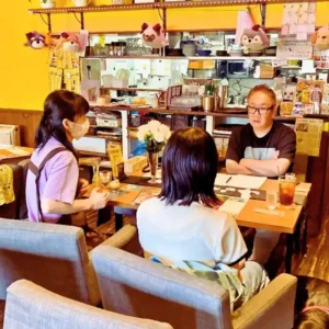 愛知県春日井市のカフェレストラン「ワンぽてぃと」にて、オーナーの小栗加奈さん（左）、とまり木さん（中央）、東洋経済オンラインの記者（右）が、若者支援の取り組みについて取材を受けている様子。
