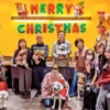 クリスマスパーティー仕様のカフェ「ワンぽてぃと」で、第5回わちゃわちゃの会に参加した飼い主と犬たちの集合写真。サンタの服を着た犬もおり、楽しそうな雰囲気が伝わる。