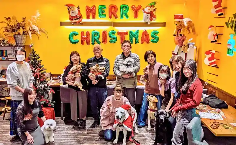 クリスマス仕様の店内で楽しむ第5回わちゃわちゃの会の参加者と犬たち