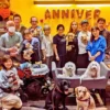 第9回わちゃわちゃの会に参加した犬と飼-い主たちの記念写真。「ANNIVERSARY」の風船が飾られた店内で、初参加の犬も安心して過ごしている様子がわかる。