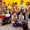 カフェレストラン「ワンぽてぃと」の犬の交流会「わちゃわちゃ会」での集合写真。犬を抱いた複数の男女と、ベビーカーに乗った犬たち、大型犬が笑顔でカメラを見ている。