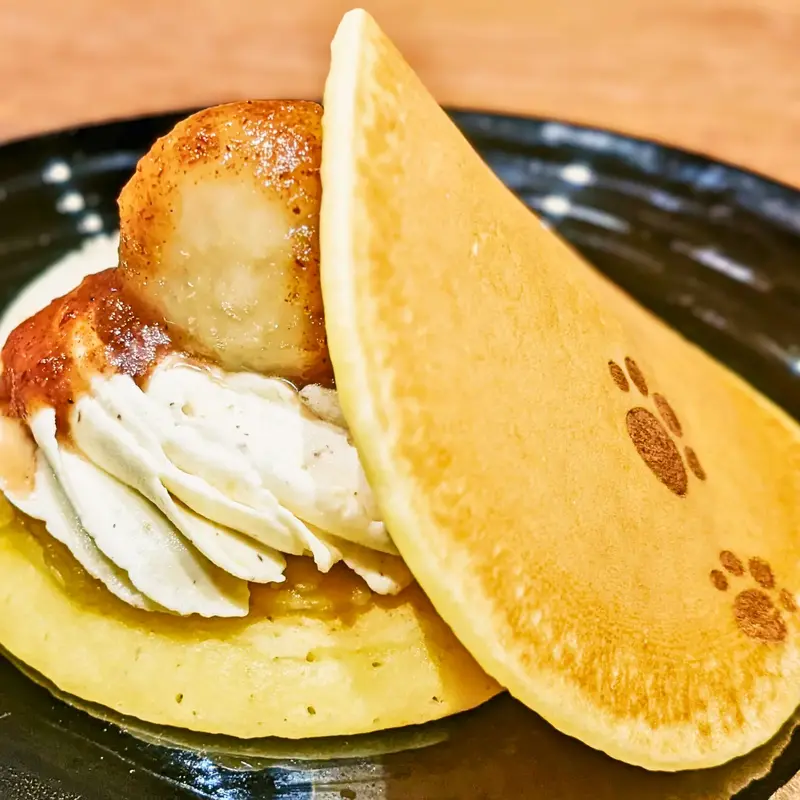 犬の肉球の焼き印が入ったどら焼き「蜜いもっち」。生地の間からたっぷりのホイップクリームと蜜芋が見えている。