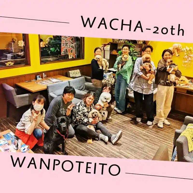 ドッグカフェ「ワンぽてぃと」の店内で、看板犬を抱っこしたスタッフやお客様が笑顔で並んでいる集合写真