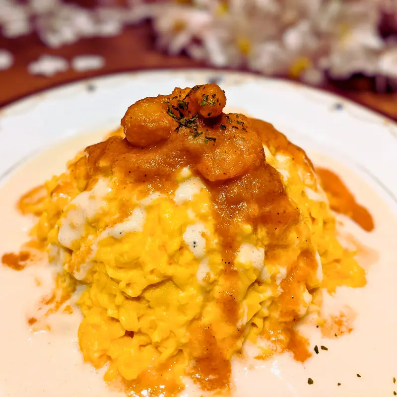 ふわとろの卵の上に、鮮やかなアメリケーヌソースと米粉・豆乳で作られた白いソースがかかった特製オムライス