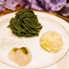 白いお皿に盛り付けられた、鮮やかな緑色の濃厚抹茶モンブランと、バニラアイス、特製抹茶ソースがかかった2個の白玉