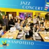 春日井市のカフェレストラン「ワンぽてぃと」で開催された5月のJAZZ LIVE。満員御礼となった店内で、出演した女性トリオバンドと集まったお客様、愛犬たちが笑顔で写っている集合写真。