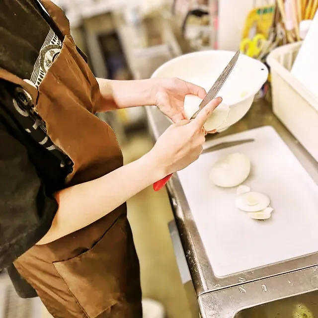 カフェレストランワンぽてぃとで、若者たちが真面目にお弁当の仕込みや作業に向き合っている様子の写真