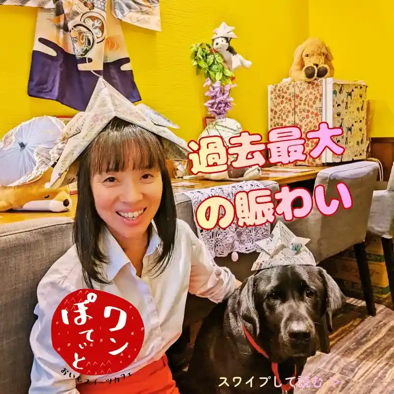 新聞紙の兜を被った店主と、同じく兜を被った看板犬の黒ラブラドール・オリバー