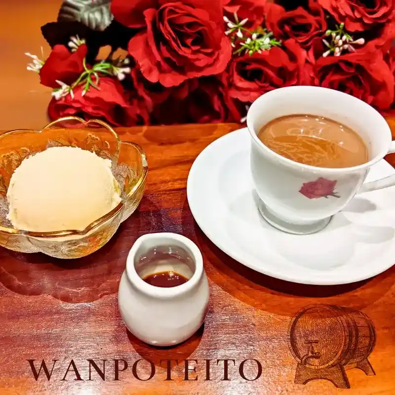 赤い薔薇を背景にした、ラム酒とスパイスが香る濃厚なホットチョコレートとバニラアイスクリームのセット。