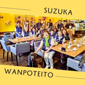 鈴鹿市から視察に訪れた民生委員の皆様とワンぽてぃとスタッフ、手前に座る看板犬オリバーの笑顔の集合写真
