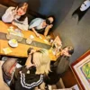 春日井市のカフェレストラン「ワンぽてぃと」で開催された、とまり木スタッフたちによる女子会の様子。テーブルを囲んで和やかにピースサインをして談笑しています。